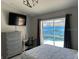 Bedroom with neutral color palette, TV, dresser, and sliding glass doors to pool area at 5494 Sabal Trace Dr, North Port, FL 34287
