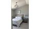 This charming bedroom features a bed with a grey headboard, nightstand, and neutral walls at 5494 Sabal Trace Dr, North Port, FL 34287