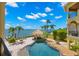 Aerial view of a backyard oasis with a tiki bar, pool, and waterfront access at 611 1St S Ave, Tierra Verde, FL 33715