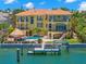 Waterfront backyard features a custom pool, tiki bar, and covered patio area with dock access at 611 1St S Ave, Tierra Verde, FL 33715