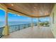 Large balcony overlooking the water with tile floors, white columns, and iron railing at 611 1St S Ave, Tierra Verde, FL 33715