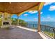 Spacious covered balcony with an outdoor fireplace and panoramic views of the waterfront at 611 1St S Ave, Tierra Verde, FL 33715