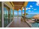 Balcony with decorative railings and columns overlooking the bay, palms, and pool at 611 1St S Ave, Tierra Verde, FL 33715