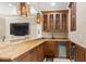Entertaining area with wooden wet bar, mini fridge, wooden cabinets, and granite countertop at 611 1St S Ave, Tierra Verde, FL 33715