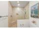 Bathroom with glass-enclosed shower featuring a built-in bench and tiled walls at 611 1St S Ave, Tierra Verde, FL 33715