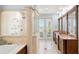 Bright bathroom with a glass-enclosed shower, a soaking tub, double vanities, and natural light at 611 1St S Ave, Tierra Verde, FL 33715
