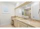 Elegant bathroom vanity with marble countertop, window, and view of the glass shower at 611 1St S Ave, Tierra Verde, FL 33715