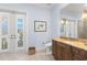Bathroom featuring a granite-topped vanity, French doors, and travertine floors at 611 1St S Ave, Tierra Verde, FL 33715