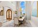 Elegant dining room with chandelier, arched doorway, and large windows providing abundant natural light at 611 1St S Ave, Tierra Verde, FL 33715