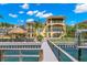 Back exterior of the home showcasing multi-level balconies, a fenced yard, and a private dock with water access at 611 1St S Ave, Tierra Verde, FL 33715
