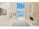 Bright living room featuring a fireplace, soaring ceilings, a large bay window with scenic water views at 611 1St S Ave, Tierra Verde, FL 33715