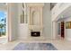 Elegant living room with a custom fireplace, marble flooring and large windows looking out to water at 611 1St S Ave, Tierra Verde, FL 33715