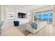 Modern living room featuring built-in shelving, comfortable seating, and expansive water views at 611 1St S Ave, Tierra Verde, FL 33715