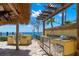 Outdoor kitchen and dining area featuring stainless steel appliances, a sink, and a water view at 611 1St S Ave, Tierra Verde, FL 33715
