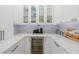 Closer view of butler's pantry featuring a beverage center, storage and marble backsplash at 611 1St S Ave, Tierra Verde, FL 33715