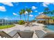 Luxurious backyard pool area with sun loungers and an outdoor tiki bar at 611 1St S Ave, Tierra Verde, FL 33715
