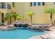 Custom pool with waterfall feature and rock accents offers a tropical oasis in the backyard at 611 1St S Ave, Tierra Verde, FL 33715