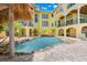 Inviting pool area with tropical landscaping, waterfall feature, and a charming tiki hut for relaxing by the water at 611 1St S Ave, Tierra Verde, FL 33715
