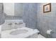 Stylish powder room with blue wallpaper, a marble countertop, and elegant fixtures creating a sophisticated space at 611 1St S Ave, Tierra Verde, FL 33715
