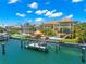 Waterfront home featuring a boat dock, outdoor kitchen, pool, and covered patio with water views at 611 1St S Ave, Tierra Verde, FL 33715