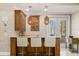 A stylish wet bar with unique lighting and seating is perfect for entertaining guests at 611 1St S Ave, Tierra Verde, FL 33715