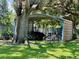 Outdoor bike storage area sheltered by a metal awning, surrounded by greenery and a mature tree at 702 Lyndhurst St # 822, Dunedin, FL 34698
