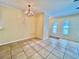 Open-concept dining area featuring neutral tile floors, modern lighting fixture, and seamless flow to other living spaces at 702 Lyndhurst St # 822, Dunedin, FL 34698