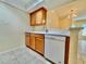 Kitchen featuring wood cabinets, white countertops, and a white dishwasher at 702 Lyndhurst St # 822, Dunedin, FL 34698