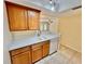 Bright kitchen featuring wood cabinets, white countertops, tile flooring, and stainless steel dishwasher at 702 Lyndhurst St # 822, Dunedin, FL 34698