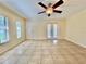 Spacious living room with neutral tile floors, modern ceiling fan, and access to the outdoor balcony at 702 Lyndhurst St # 822, Dunedin, FL 34698
