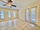 Bright and airy living room with access to the balcony, neutral paint colors, and stylish ceiling fan at 702 Lyndhurst St # 822, Dunedin, FL 34698