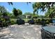 Outdoor patio with brick pavers, wrought iron furniture, and barbecue grills under a clear sky at 702 Lyndhurst St # 822, Dunedin, FL 34698