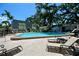 Community pool area surrounded by lounge chairs, landscaping, and building exteriors at 702 Lyndhurst St # 822, Dunedin, FL 34698