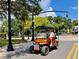 Street view of a Personal driving an orange golf cart on a sunny day at 702 Lyndhurst St # 822, Dunedin, FL 34698
