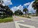 Street view in a lushly landscaped neighborhood with crosswalks and visible signage at 702 Lyndhurst St # 822, Dunedin, FL 34698