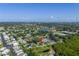 Aerial view showing the home in a vibrant neighborhood with a community lake at 7400 Locust Ne St, St Petersburg, FL 33702