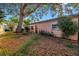 The backyard features a mature tree with surrounding landscaping, along with a neutral-colored house at 7400 Locust Ne St, St Petersburg, FL 33702