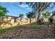 A spacious backyard with a wooden fence, covered in leaves with an established tree providing plenty of shade at 7400 Locust Ne St, St Petersburg, FL 33702