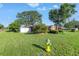 A well-manicured front lawn is framed by mature trees, accompanied by colorful landscaping, and a bright yellow fire hydrant at 7400 Locust Ne St, St Petersburg, FL 33702
