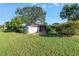 Landscaped front yard with lawn, a white fence, and mature trees provides privacy and curb appeal at 7400 Locust Ne St, St Petersburg, FL 33702