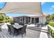 Inviting back deck with a dining table, lounge chairs, and a screened-in lanai, perfect for enjoying outdoor living at 805 Leisey Cir, Ruskin, FL 33570