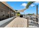 Spacious wooden deck overlooking the water, complete with seating, shade, and a screened-in porch at 805 Leisey Cir, Ruskin, FL 33570