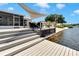 Multi-level backyard deck with waterfront access and covered dining area with views of dock and neighborhood at 805 Leisey Cir, Ruskin, FL 33570