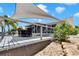 Well-maintained backyard with a spacious deck, covered dining area, and tropical landscaping, creating a private outdoor oasis at 805 Leisey Cir, Ruskin, FL 33570