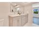 Bright bathroom with double vanity, marble countertop, and a view into the bedroom at 805 Leisey Cir, Ruskin, FL 33570