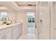 Bright bathroom with double vanity, white marble flooring, and a glass shower enclosure at 805 Leisey Cir, Ruskin, FL 33570