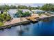 A waterfront home with a private dock, a wooden deck, and tropical landscaping at 805 Leisey Cir, Ruskin, FL 33570