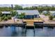 The home has a waterfront, wooden deck, a private dock, and tropical landscaping at 805 Leisey Cir, Ruskin, FL 33570