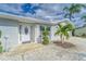 Close-up of the front entrance, featuring manicured bushes, a patterned walkway and a white front door at 805 Leisey Cir, Ruskin, FL 33570