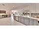 Open-concept kitchen with stainless appliances, gray cabinets, and marble countertops leading to a bright living space at 805 Leisey Cir, Ruskin, FL 33570